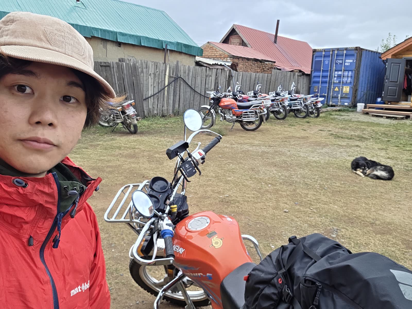 借りたバイクと自撮り、後ろで寝ている犬