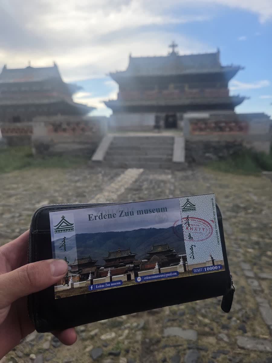 エルデネゾーの入場券を持つ手と、その奥の寺院の建物
