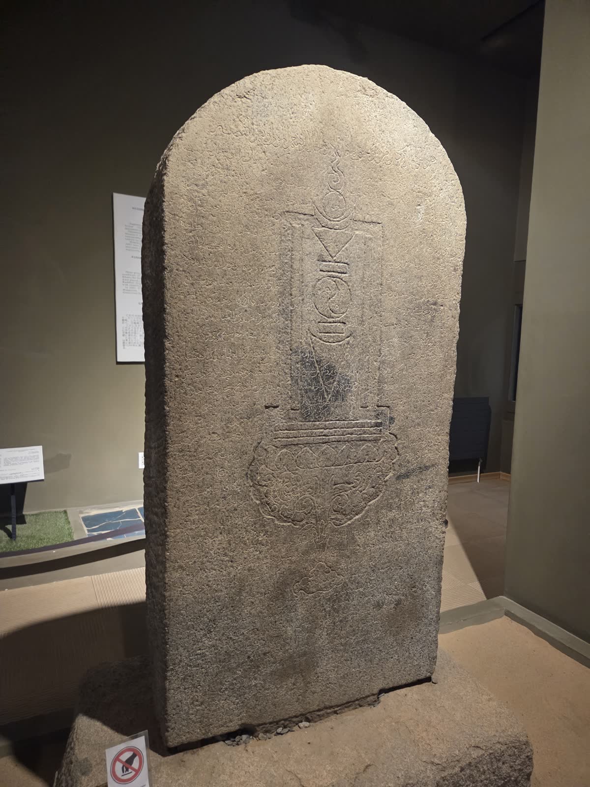 アラビア文字のペルシア語が刻まれた、アーチ形の頭部を持つ石碑